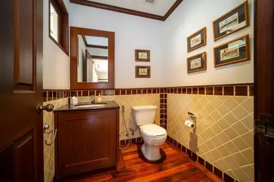 a bathroom with a toilet and a sink and a mirror at Saitaan,4BR seaside garden pool villa, Laguna area in Bang Tao Beach