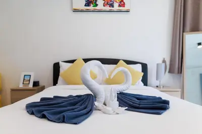 two swans are sitting on a bed with towels at Modern & fun pool villa at Kamala regent in Kamala Beach