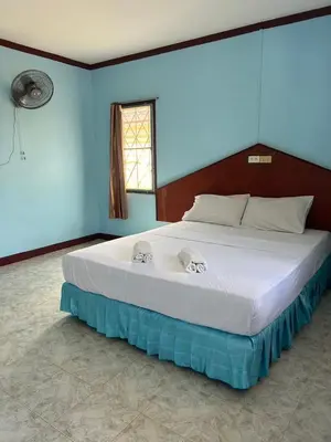 a large bed in a bedroom with a blue wall at Adam Bungalows in Ao Nang Beach