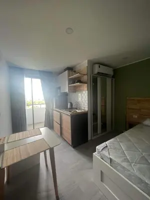 a room with a bed and a kitchen with a table at The Tower Condo Phase3 in Ban Klang