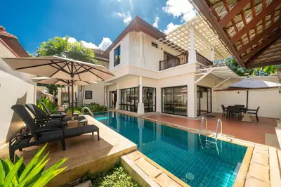 a villa with a swimming pool and a house at Angsana Villas Laguna-3 Bedroom Pool Villa in Phuket Town