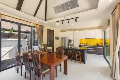 a kitchen and dining room with a wooden table and chairs at Secret Balinese Escape villla Eva in Rawai Beach