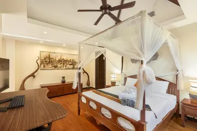 a bedroom with a bed with a ceiling fan and a desk at Secret Balinese Escape villla Eva in Rawai Beach