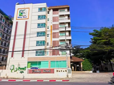 a tall white building on the side of a street at Quiet Patong Apartment near Night Life & Good Food in Patong Beach