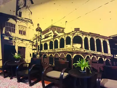 a mural of a building with tables and chairs at Phuket Sunny Hostel in Phuket Town