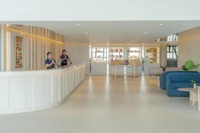 two people standing at a counter in a lobby at The Yama Hotel Phuket in Kata Beach