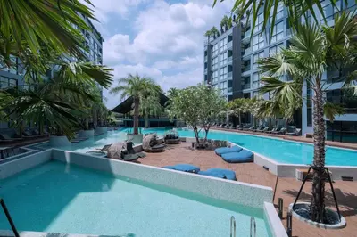 a large swimming pool with palm trees and a building at Tropics Kamala Hill View Suite CTG P610 near Beach and Fantasea in Kamala Beach