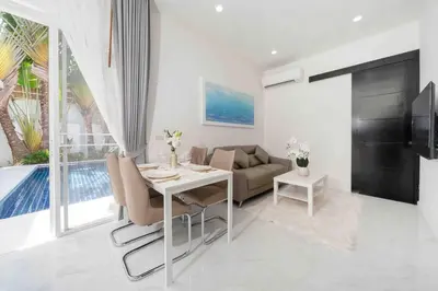 a living room with a table and a couch at Brand New 3 Bedroom Pool Villa in Ban Saiyuan (1)