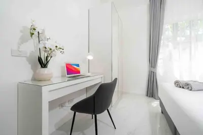 a white bedroom with a desk and a chair at Brand New 3 Bedroom Pool Villa in Ban Saiyuan (1)