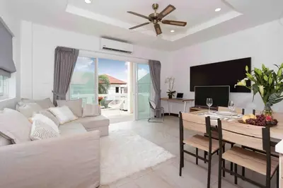 a living room with a couch and a tv and a table at 1 bedroom apartment in Nai Harn in Ban Saiyuan (1)