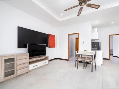 a living room with a flat screen tv and a table at 1 bedroom apartment in Nai Harn in Ban Saiyuan (1)