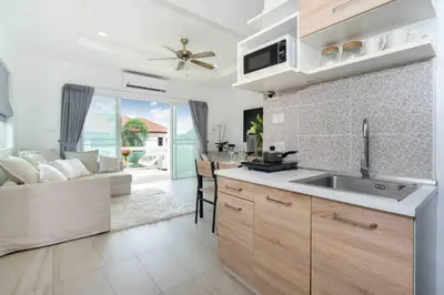a kitchen with a sink and a living room at 1 bedroom apartment in Nai Harn in Ban Saiyuan (1)