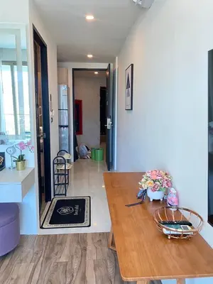 a living room with a wooden table and a kitchen at OCEANA HOME Phuket Kamala in Kamala Beach