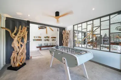 a game room with a foosball table in the middle at Contemporary Eden - Villa Jeladore, 5BR, Garden & Pool, near Laguna in Bang Tao Beach