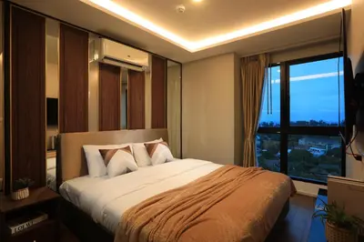 a bedroom with a large bed with a large window at 3bdr Sea View Apartment Surin Beach by Capital Pro in Phuket Town