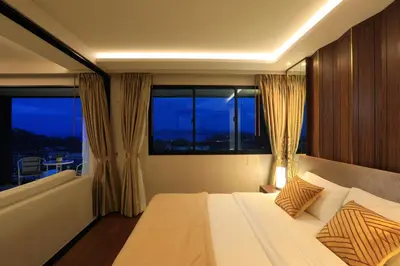 a bedroom with a large bed with a large window at 3bdr Sea View Apartment Surin Beach by Capital Pro in Phuket Town