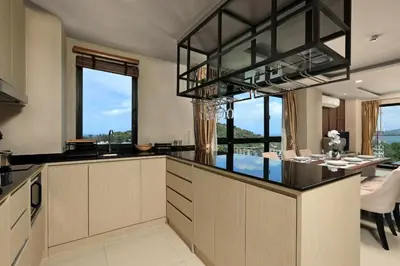 a kitchen with a large island with a dining table at 3bdr Sea View Apartment Surin Beach by Capital Pro in Phuket Town