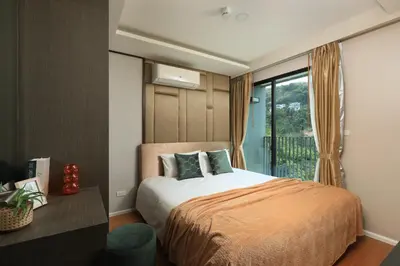 a bedroom with a bed and a large window at 3bdr Sea View Apartment Surin Beach by Capital Pro in Phuket Town