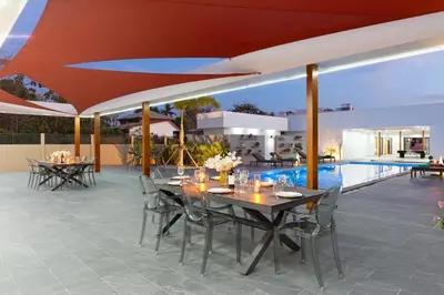 an outdoor patio with tables and chairs and a pool at Brand-new 8BR Private Pool Villa Mystic Garden in Rawai Beach