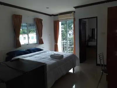 a bedroom with a large bed and a mirror at Elba Bella Guest House in Patong Beach