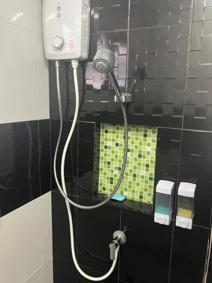 a shower in a bathroom with a hair dryer at Nacha Hostel, Koh Phi Phi, Krabi. THAILAND in Phi Phi Don