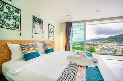 a bedroom with a large bed with a large window at \u82ad\u4e1cVilla1\u4e09\u5367\u53cc\u6d77\u666f\u6cf3\u6c60\u522b\u5885\u4e2d\u82f1\u6cf0\u4e09\u6587\u7ba1\u5bb6 in Patong Beach