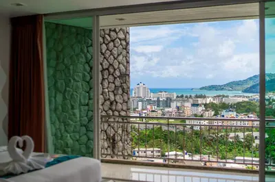 a bedroom with a view of a city from a window at \u82ad\u4e1cVilla2:\u56db\u5367\u6d77\u666f\u522b\u5885 \u53cc\u6d77\u666f \u4e2d\u82f1\u6cf0\u4e09\u6587\u7ba1\u5bb6 in Patong Beach