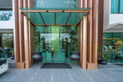 a glass entrance to a building with chairs and plants at Sea view apartment at Oceana by Lofty in Kamala Beach