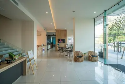 a living room with a staircase and a table and chairs at Sea view apartment at Oceana by Lofty in Kamala Beach
