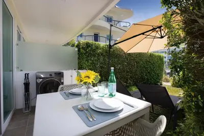 a white table with plates and an umbrella on a patio at Woodbridge Property at Karon Butterfly in Karon Beach