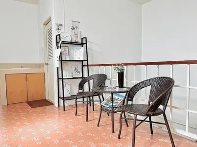 a table and four chairs in a room at Genesis Urban Phuket in Ban Lo Long