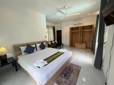 a bedroom with a large white bed with blue pillows at Kata Sea Blue Villa in Kata Beach
