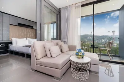 a living room with a couch and a bed at Tropics Kamala Hill View Suite CTG P614, near Beach and Fantasea in Kamala Beach