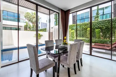 a dining room with a table and chairs and large windows at \u3010\u8d85\u503c\u30112\u5367\u5ba4\u522b\u5885\u3010\u5bbd\u655e\u8212\u9002\u301113\u7c73\u957f\u79c1\u5bb6\u6cf3\u6c60\uff0c\u914d\u5957\u9f50\u5168\u51fa\u884c\u65b9\u4fbf\uff0c\u6b65\u884c700\u7c73\u5230kamala\u6d77\u6ee9 V03 in Kamala Beach