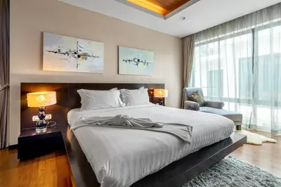 a bedroom with a large bed and a chair at \u3010\u8d85\u503c\u30112\u5367\u5ba4\u522b\u5885\u3010\u5bbd\u655e\u8212\u9002\u301113\u7c73\u957f\u79c1\u5bb6\u6cf3\u6c60\uff0c\u914d\u5957\u9f50\u5168\u51fa\u884c\u65b9\u4fbf\uff0c\u6b65\u884c700\u7c73\u5230kamala\u6d77\u6ee9 V03 in Kamala Beach