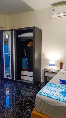 a bedroom with a bed and a cabinet with a desk at Kata Lina guesthouse in Kata Beach