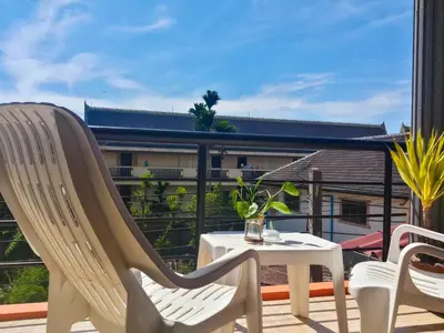 a patio with a table and chairs and a balcony at Kata Lina guesthouse in Kata Beach