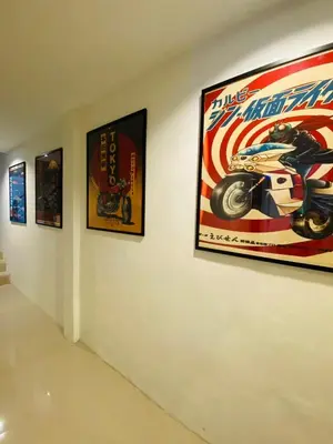 a wall with pictures of a motorcycle on it at Jhen House in Nai Yang Beach