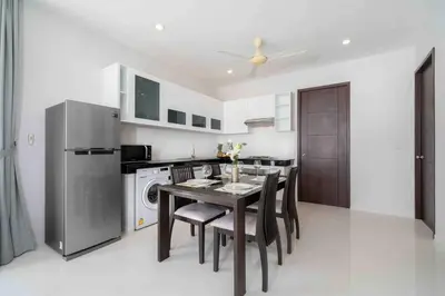 a dining room with a table and a kitchen at Modern Villa , 2-bedroom, Rawai in Ban Saiyuan (1)