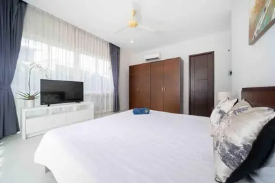 a bedroom with a large white bed and a television at Modern Villa , 2-bedroom, Rawai in Ban Saiyuan (1)