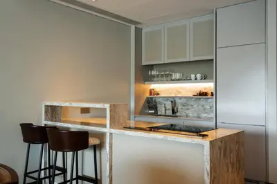a kitchen with a counter with bar stools at ANGSANA Oceanview apartments with jacuzzi in Laguna area in Bang Tao Beach