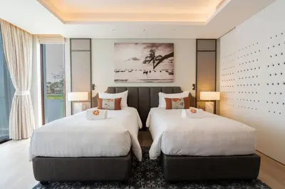two beds in a large room with a window at ANGSANA Oceanview apartments with jacuzzi in Laguna area in Bang Tao Beach