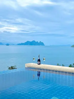 a bottle of wine and two glasses in a swimming pool at Stunning 5 bedrooms Villa with Panoramic Sea View in Por Bay
