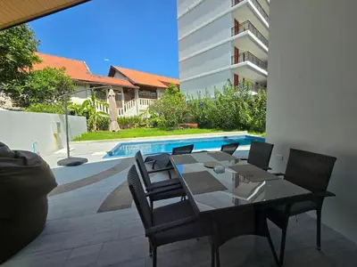 a dining table and chairs next to a swimming pool at PoolVilla 234 Patong in Patong Beach