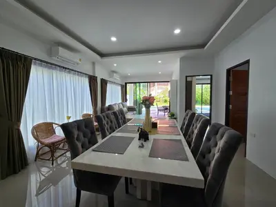 a dining room with a long table and chairs at PoolVilla 234 Patong in Patong Beach