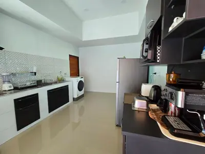 a kitchen with a refrigerator and a counter top at PoolVilla 234 Patong in Patong Beach