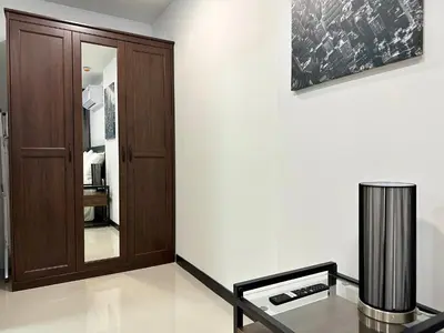 a room with a wooden door and a glass table at 1bdr Pool Access Apartment Rawai Beach Condominium by Capital Pro in Phuket Town