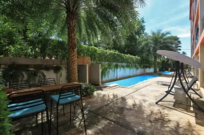 a patio with a table and chairs next to a pool at 1bdr Pool Access Apartment Rawai Beach Condominium by Capital Pro in Phuket Town