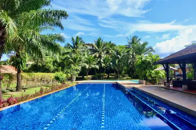 a swimming pool in a resort with palm trees at 3BR Casa Azul - Beachfront Home in Laguna & Layan Chom Tawan and Maan Tawan Residences in Phuket Town