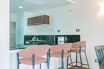 a kitchen with pink chairs and a counter at 3BR Casa Azul - Beachfront Home in Laguna & Layan Chom Tawan and Maan Tawan Residences in Phuket Town
